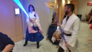 Yuna from Final Fantasy and a random Jedi try out each other's weapons.